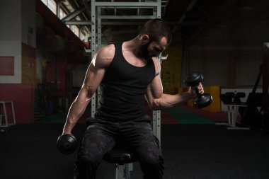 Pazı egzersiz Dumbbells ile genç adam