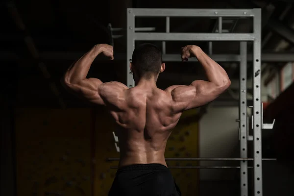 Jovem halterofilista Flexing traseiro duplo bíceps dose — Fotografia de Stock