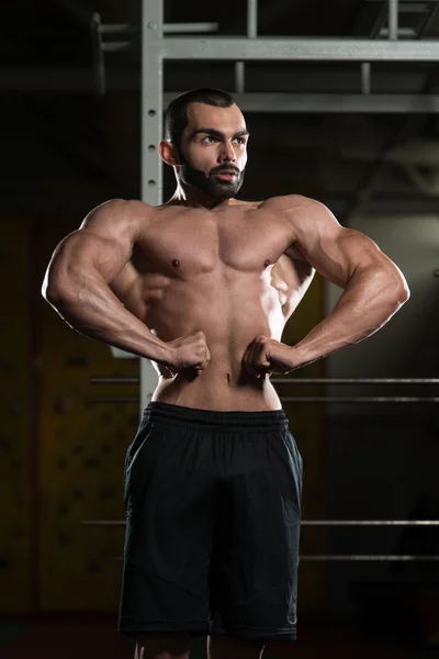 Bodybuilder Flexing främre lat sprida pose — Stockfoto