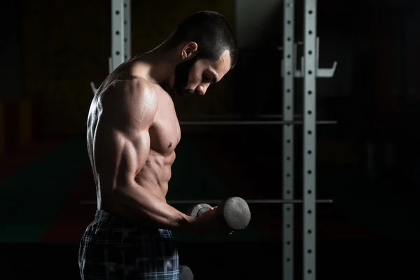 A fiatalember a súlyzó gyakorolja a bicepsz — Stock Fotó