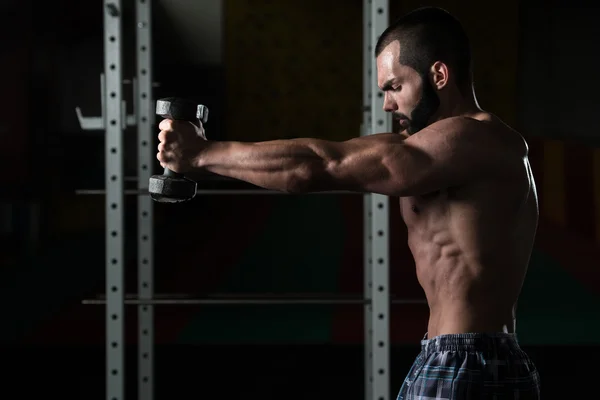 Giovane uomo con manubri che esercitano le spalle — Foto Stock