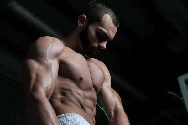 Здоровый молодой человек демонстрирует мышцы — стоковое фото