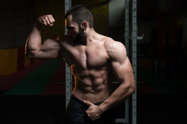 Unga Bodybuilder flexar muskler dubbel Biceps utgör — Stockfoto
