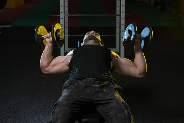 Joven culturista haciendo ejercicio en el pecho con sombrillas — Foto de Stock