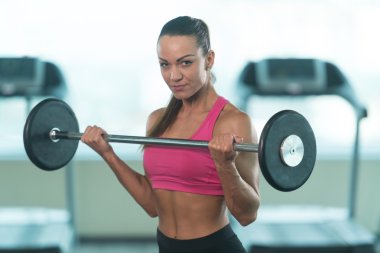 Genç kadının pazı egzersiz halter ile yapması