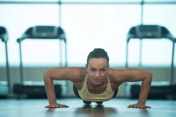 Mujer joven y saludable haciendo flexiones en el suelo — Foto de Stock