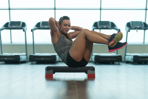 Jovem mulher fazendo exercício abdominal no degrau — Fotografia de Stock