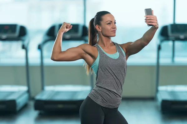 Chica bonita tomando selfie y posando bíceps Pose — Foto de Stock