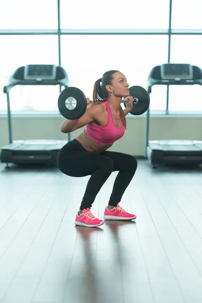 Fitness kvinna med skivstång tränar ben inuti Gym — Stockfoto