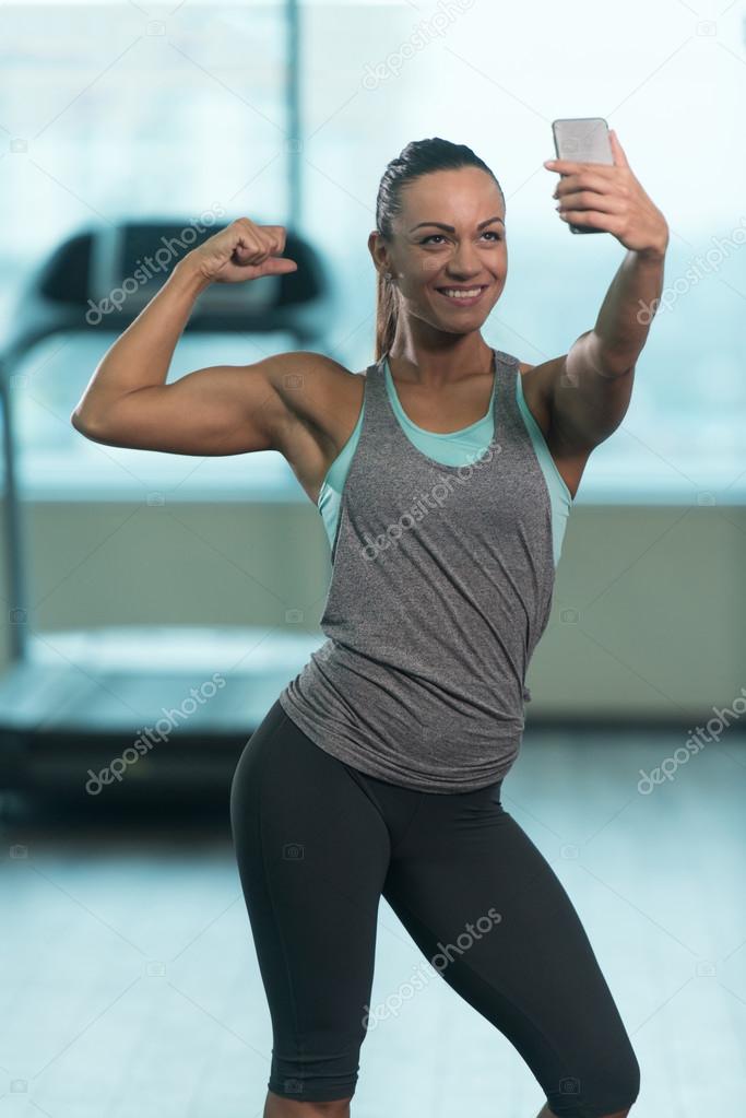 Selfie を取ると 上腕二頭筋のポーズのポーズかわいい女の子 ストック写真 C Ibrak