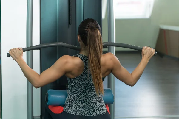 Mladá žena, která dělá zpět cvičení ve Fitness centru — Stock fotografie