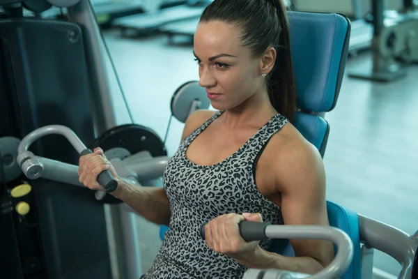 Jovem mulher fazendo exercícios de bíceps no centro de fitness — Fotografia de Stock