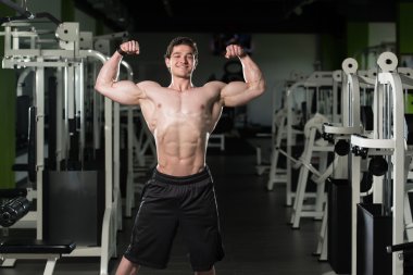 Spor salonunda açık çifte kol kası poz gerçekleştirme vücut geliştirmeci