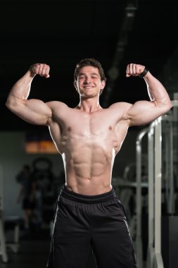 Spor salonunda açık çifte kol kası poz gerçekleştirme vücut geliştirmeci