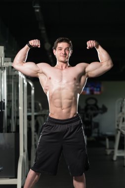 Spor salonu açık çifte kol kası poz esneme vücut geliştirmeci