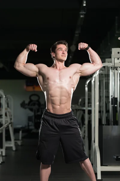 Bodybuilder Fitness Model Posant des biceps doubles après des exercices — Photo