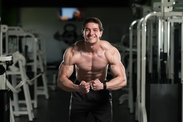 Muskulös man flexar muskler i gymmet — Stockfoto