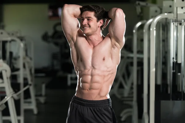 Здоровый молодой человек демонстрирует мышцы — стоковое фото