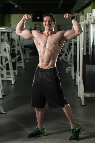Bodybuilder Performing Front Double Biceps Pose In Gym - Stock Image. 