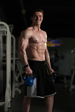 Genç adam su ısıtıcısı çan ile egzersiz
