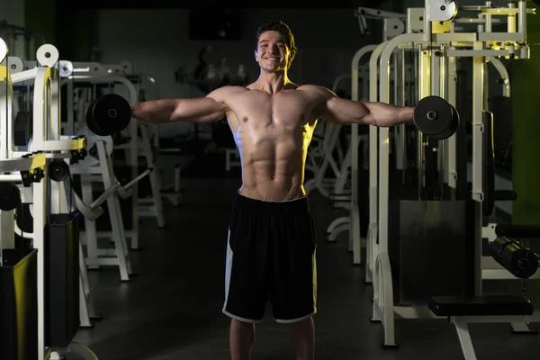 Schultern mit Kurzhanteln im Fitnessstudio — Stockfoto