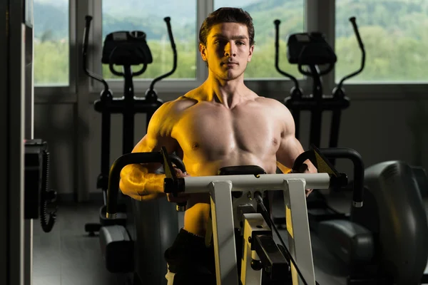 Giovane uomo che fa esercizio fisico pesante per la schiena — Foto Stock