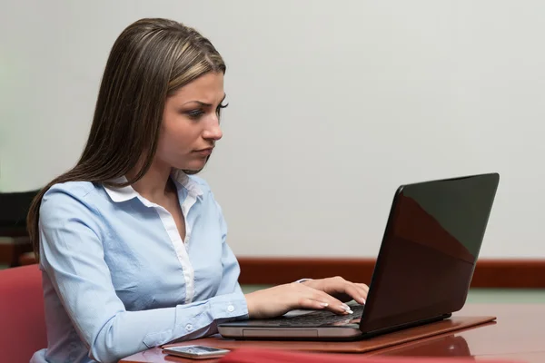 オフィスにノートパソコンを持つ若い女性が — ストック写真