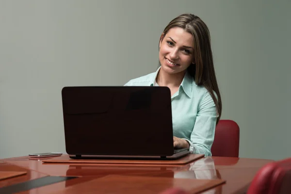 Jeune femme avec ordinateur portable dans le bureau — Photo