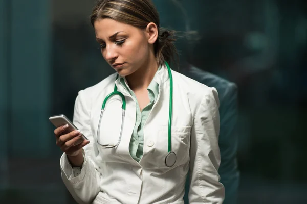 Porträt einer Ärztin mit ihrem Mobiltelefon — Stockfoto