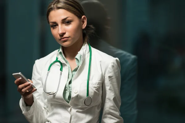 Occupato medico donna sms su suo cellulare — Foto Stock