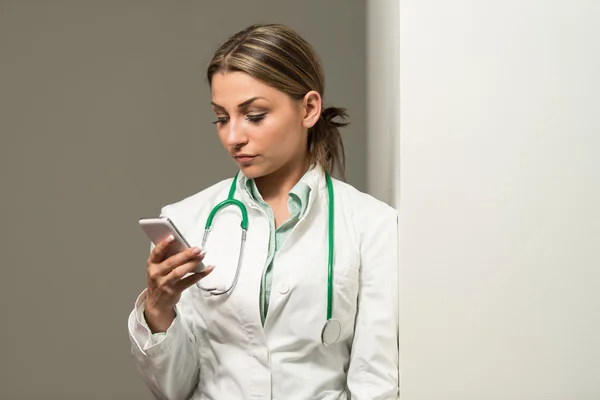 Vrouw van de dokter voor het maken van notities op mobiele telefoon — Stockfoto