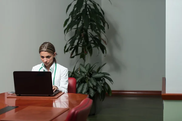 Женщина-врач с ноутбуком в офисе — стоковое фото