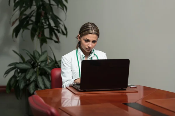 Vrouwelijke arts die werkt aan computer in Office — Stockfoto