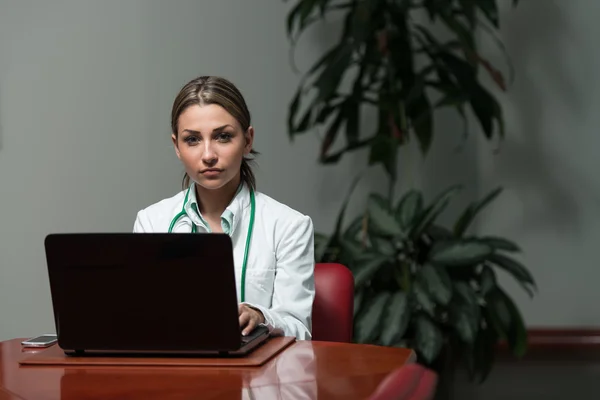 Успешная женщина-врач работает за ноутбуком — стоковое фото