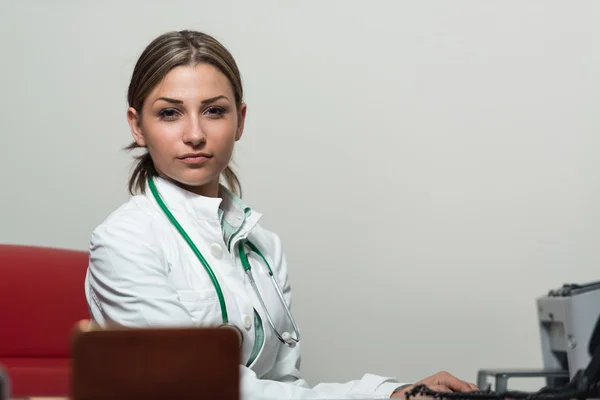 Женщина-врач работает за компьютером в офисе — стоковое фото