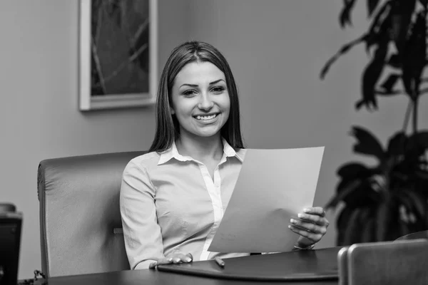 Jeune femme d'affaires au bureau regardant le papier — Photo