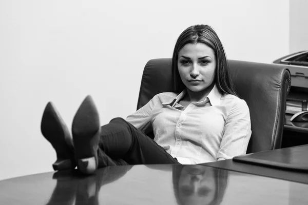 Femme d'affaires détendue avec les jambes sur le bureau — Photo