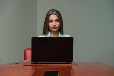 Genç güzel kız ofiste bir dizüstü bilgisayar ile