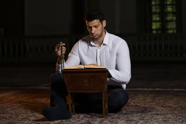 Hombre árabe musulmán leyendo el Sagrado Libro Islámico Corán —  Fotos de Stock