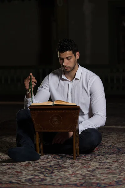 Jovem muçulmano cara leitura o Alcorão — Fotografia de Stock