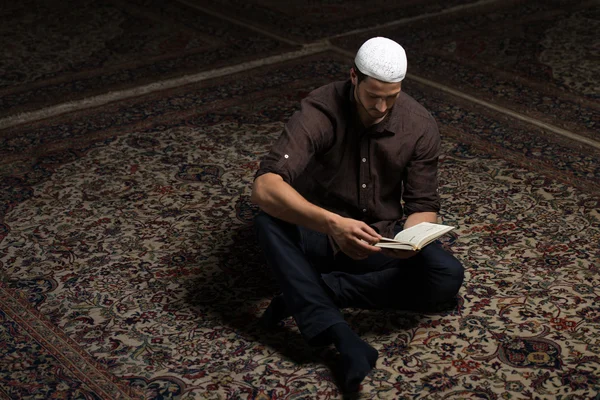 Hombre árabe musulmán leyendo el Sagrado Libro Islámico Corán —  Fotos de Stock