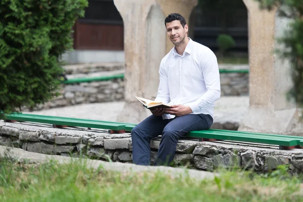 Hombre árabe musulmán leyendo el Sagrado Libro Islámico Corán — Foto de Stock