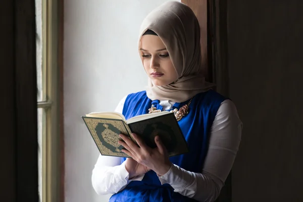Молодая мусульманка, читающая Коран — стоковое фото