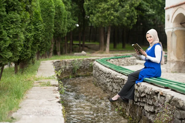 Jonge moslimvrouw lezing heilige islamitische boek Koran — Stockfoto