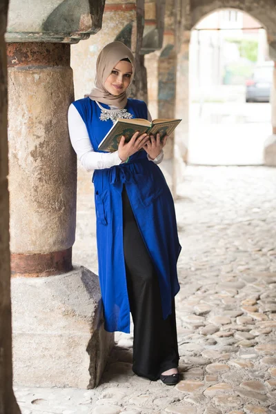 Ung muslimsk kvinna läsa heliga islamiska bok Koranen — Stockfoto