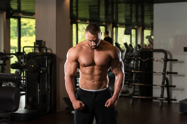 Sportler muskulöser Bodybuilder posiert in der Turnhalle — Stockfoto