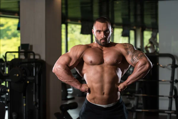 Culturista posando en el gimnasio — Foto de Stock