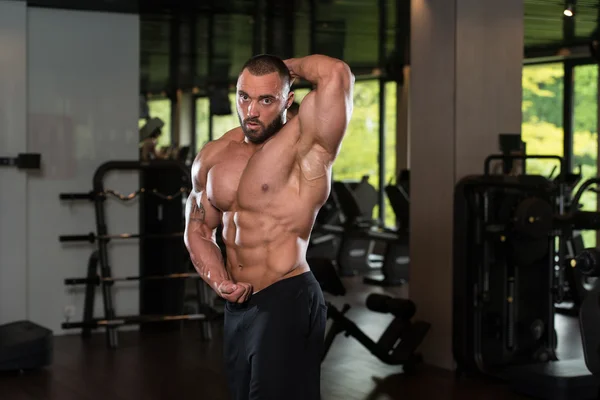 Modelo masculino musculoso posando en el gimnasio —  Fotos de Stock