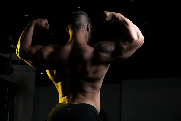 Atleta musculoso culturista posando en el gimnasio —  Fotos de Stock