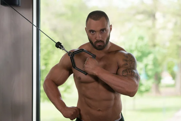 Bodybuilder trainiert Trizeps mit Seilen — Stockfoto